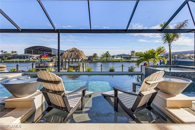 view of swimming pool featuring a lanai, an in ground hot tub, and a water view