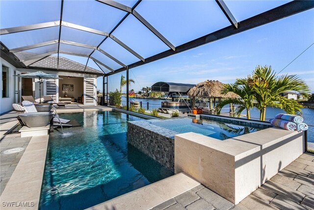 view of pool with a water view, a lanai, a jacuzzi, and a patio