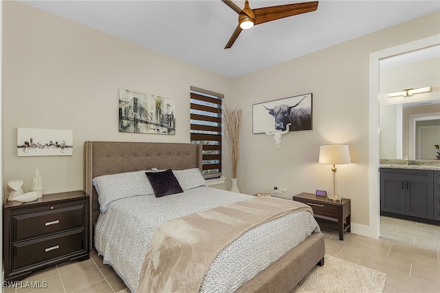 bedroom featuring a ceiling fan, a sink, baseboards, and ensuite bathroom