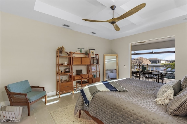 bedroom with light tile patterned floors, ceiling fan, visible vents, access to outside, and a tray ceiling