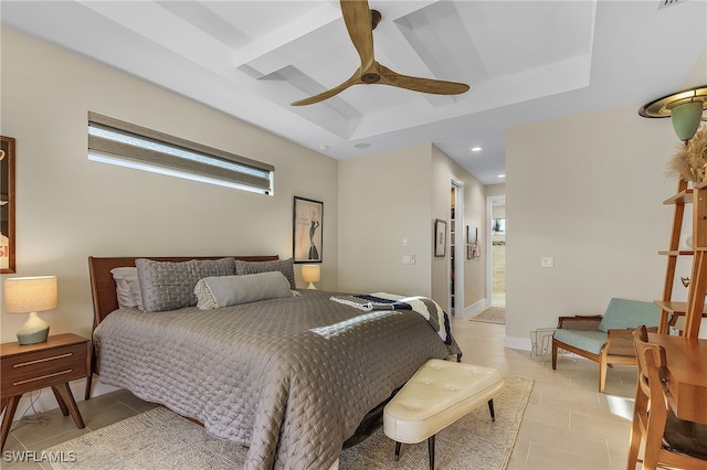 bedroom featuring light tile patterned floors, ceiling fan, a tray ceiling, and baseboards