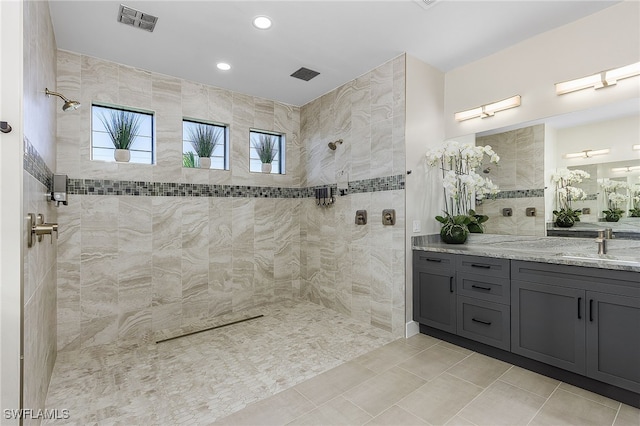 bathroom with tile patterned floors, visible vents, vanity, and walk in shower