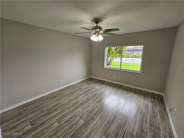 empty room with dark hardwood / wood-style floors and ceiling fan