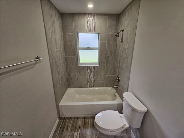 bathroom with toilet and tiled shower / bath combo