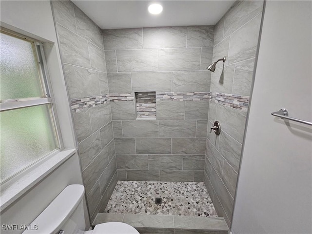 bathroom with toilet and tiled shower