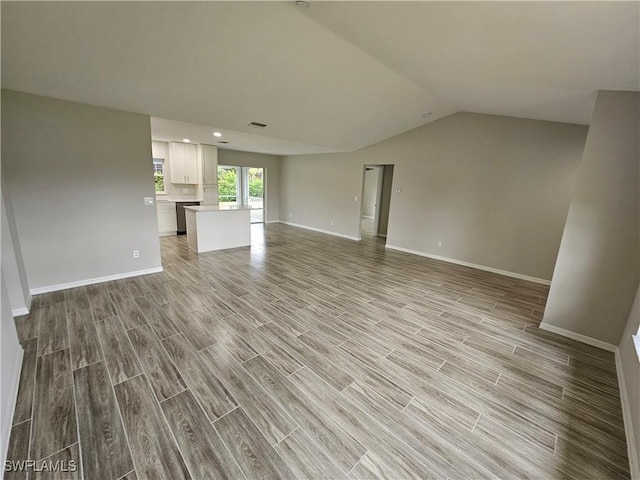 unfurnished living room with vaulted ceiling and light hardwood / wood-style floors