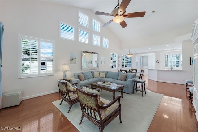 living room featuring ceiling fan, hardwood / wood-style floors, and high vaulted ceiling