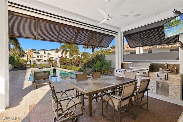 view of patio / terrace featuring area for grilling, a fenced in pool, ceiling fan, and an outdoor kitchen