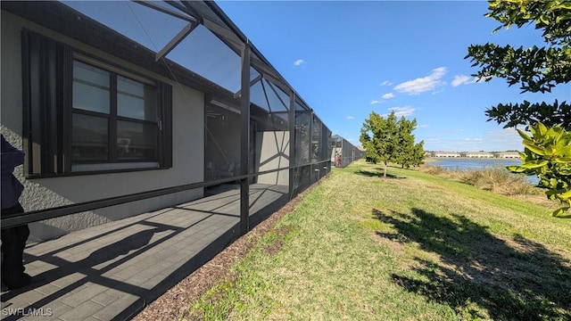 view of yard with a water view and glass enclosure