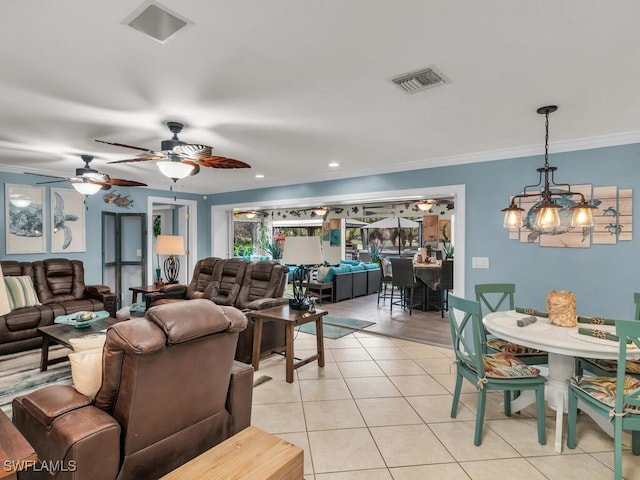 living room featuring light tile patterned floors, crown molding, and ceiling fan