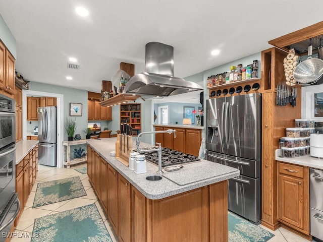 kitchen featuring island exhaust hood, appliances with stainless steel finishes, a center island, and light tile patterned floors