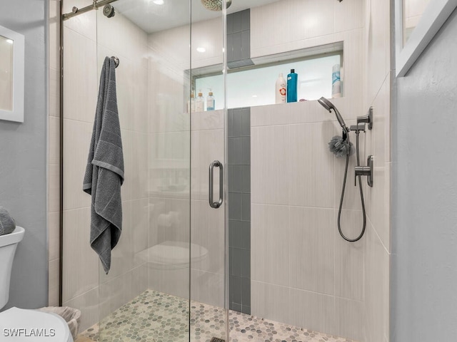 bathroom featuring an enclosed shower and toilet