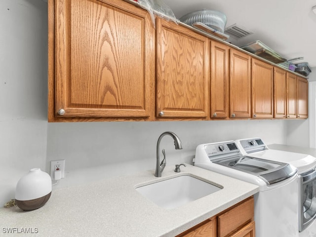 washroom featuring cabinets, separate washer and dryer, and sink