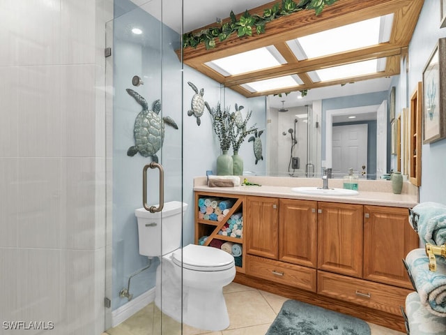 bathroom with a skylight, vanity, a shower with shower door, tile patterned floors, and toilet