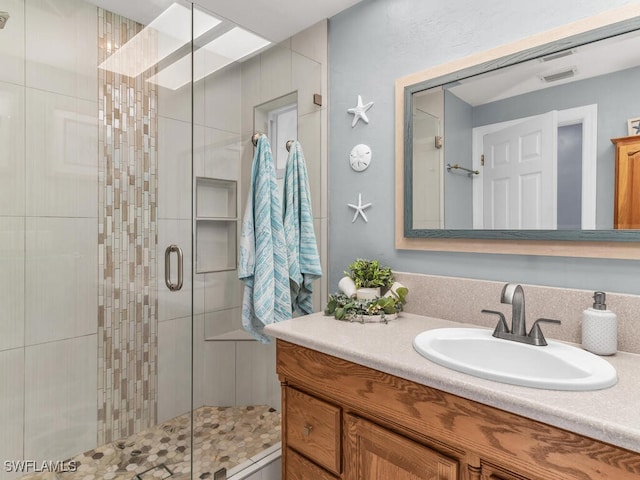 bathroom with a shower with door and vanity