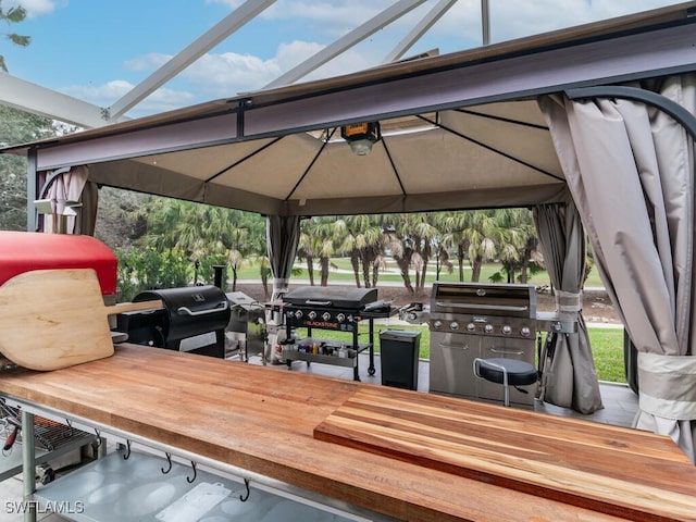 wooden deck with a gazebo and area for grilling