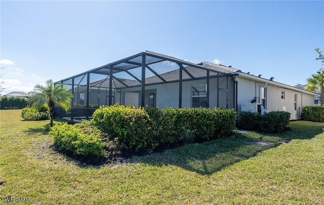 view of home's exterior featuring a yard and glass enclosure