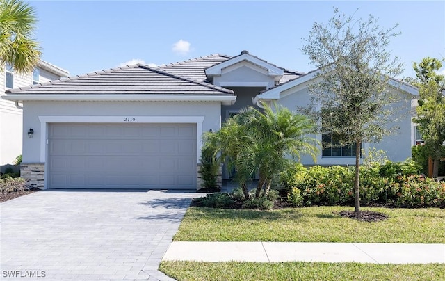 ranch-style home with a garage and a front lawn