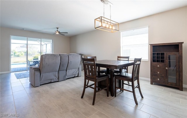 dining space with ceiling fan with notable chandelier