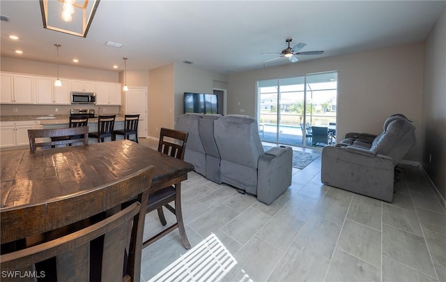 living room featuring light tile patterned floors and ceiling fan