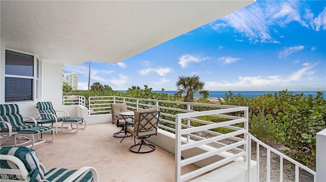 view of patio / terrace with a water view and a balcony