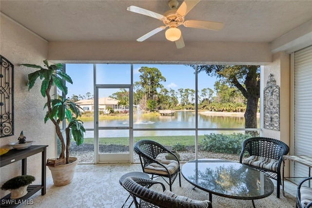 sunroom / solarium featuring a water view and ceiling fan