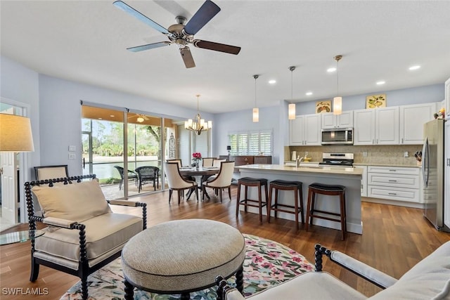 living room featuring sink, ceiling fan with notable chandelier, and dark hardwood / wood-style floors