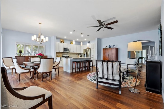 living room with ceiling fan with notable chandelier and hardwood / wood-style floors