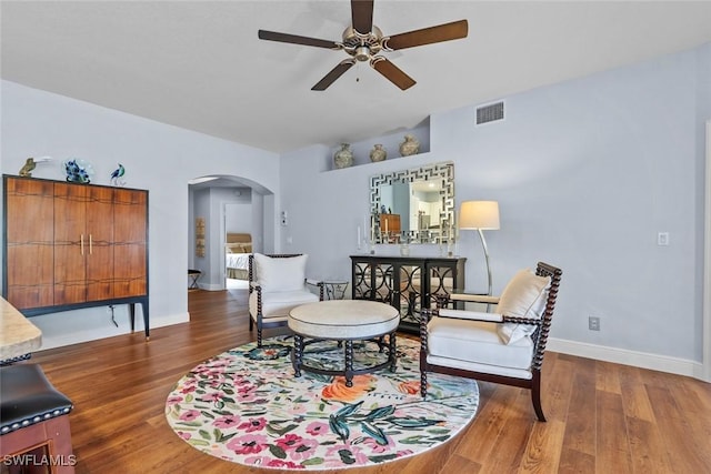 living area featuring ceiling fan and dark hardwood / wood-style floors