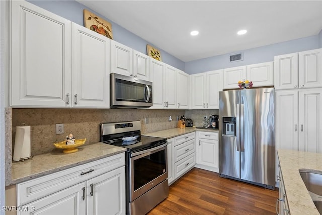 kitchen with white cabinetry, light stone counters, tasteful backsplash, and stainless steel appliances