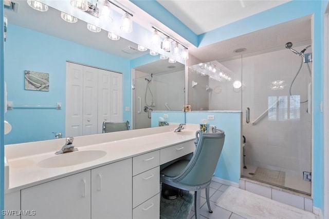 bathroom with tile patterned flooring, vanity, and walk in shower