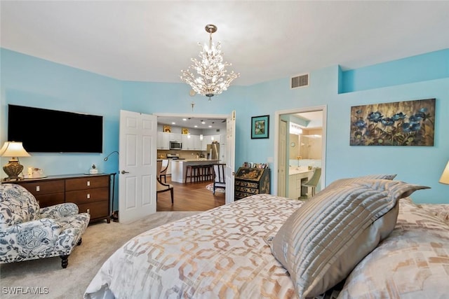 carpeted bedroom featuring connected bathroom and a chandelier