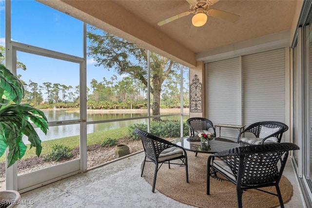 sunroom featuring a water view and ceiling fan