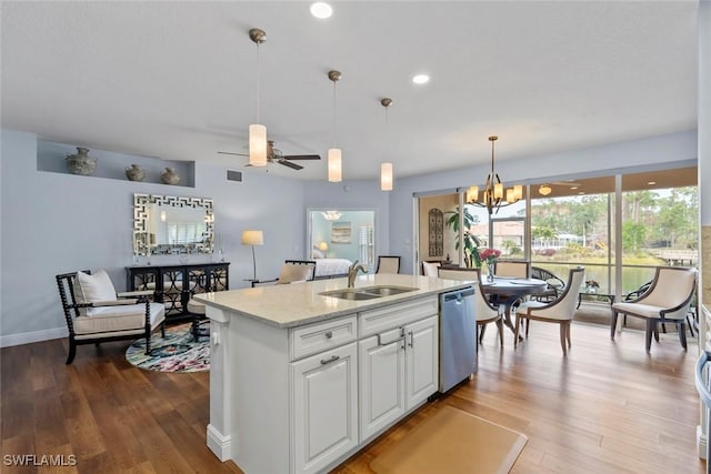 kitchen featuring pendant lighting, sink, white cabinetry, an island with sink, and stainless steel dishwasher