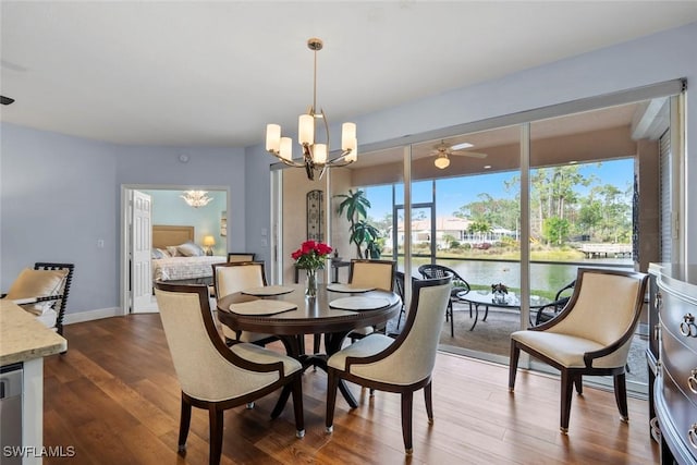 dining space featuring an inviting chandelier, hardwood / wood-style flooring, and a water view