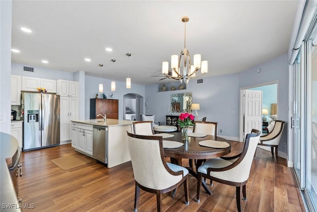 dining room with dark hardwood / wood-style flooring, a notable chandelier, and sink