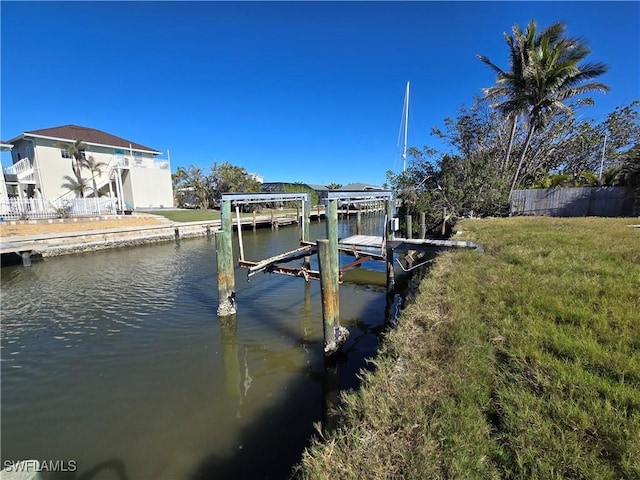 view of dock featuring a lawn and a water view