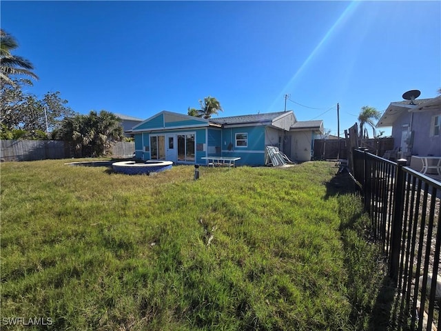 back of house with a lawn