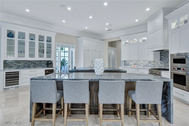 kitchen featuring a spacious island, a breakfast bar area, and wine cooler