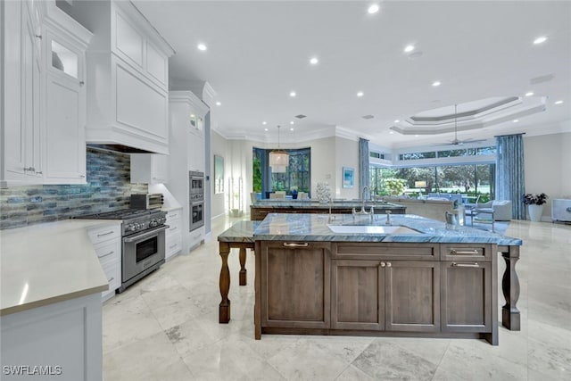 kitchen with white cabinetry, a spacious island, appliances with stainless steel finishes, and sink