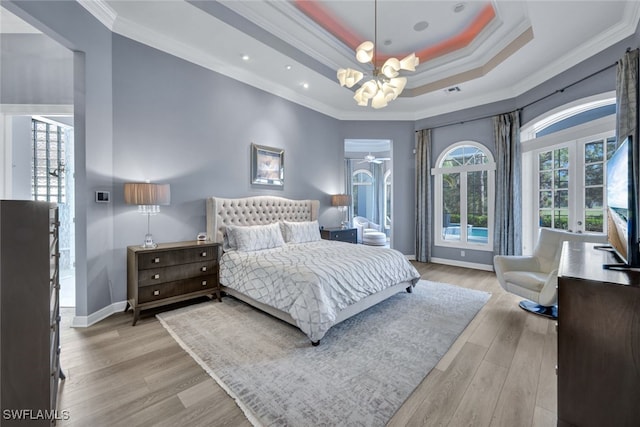 bedroom featuring light hardwood / wood-style flooring, ornamental molding, and a raised ceiling