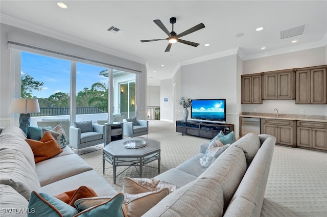 living room with crown molding, ceiling fan, sink, and light carpet