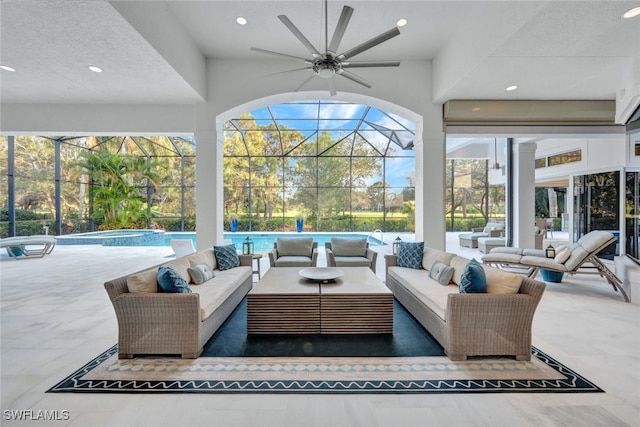 view of patio featuring a swimming pool with hot tub, an outdoor living space, ceiling fan, and glass enclosure