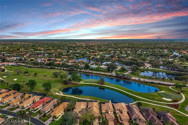 aerial view at dusk featuring a water view