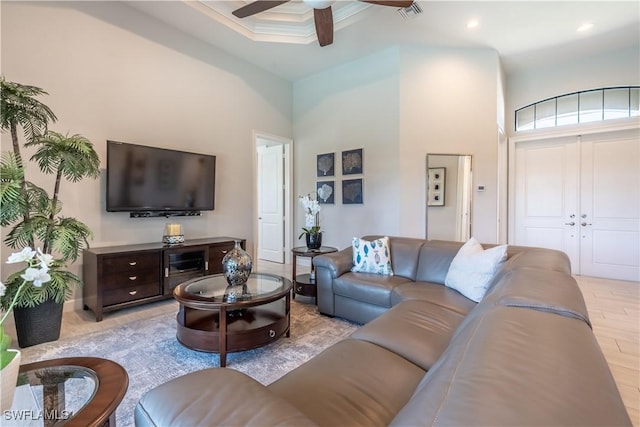 living room featuring crown molding, ceiling fan, and a high ceiling