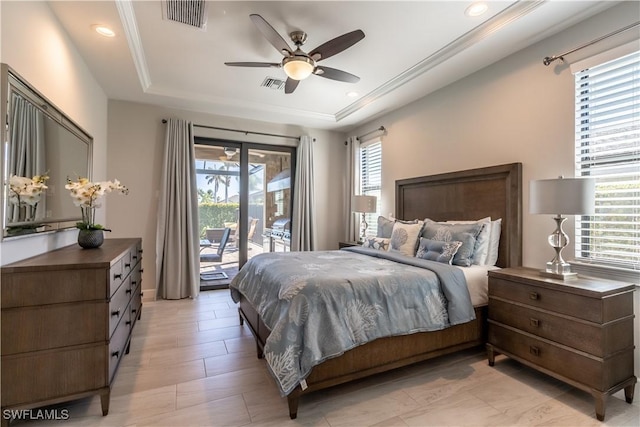 bedroom with ceiling fan, a tray ceiling, and access to outside