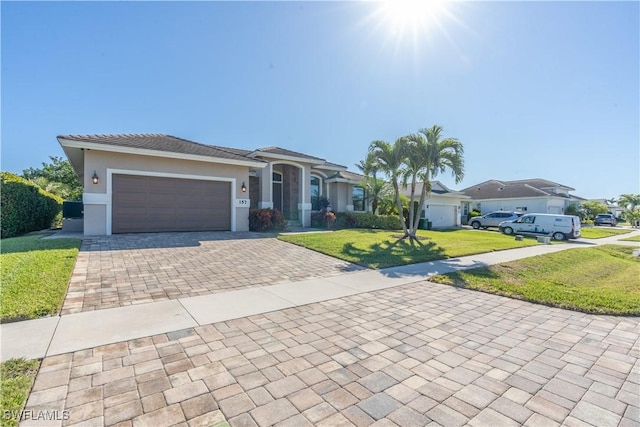 single story home featuring a garage and a front yard