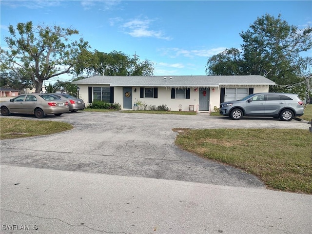 single story home featuring a garage and a front lawn