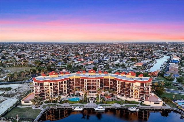 aerial view at dusk featuring a water view