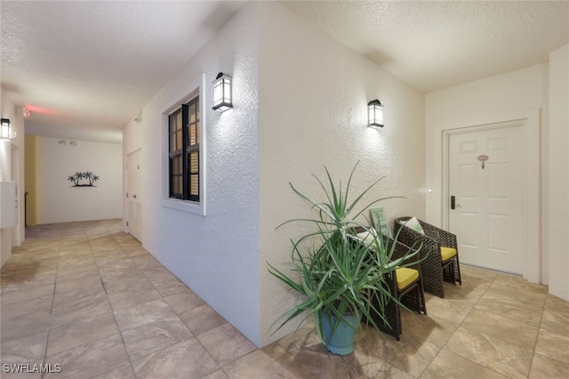 hall featuring a textured ceiling